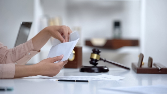 Divorced woman holding envelope with spousal maintenance