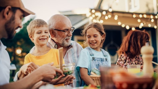 Grandparent with grandchildren at backyard BBQ
