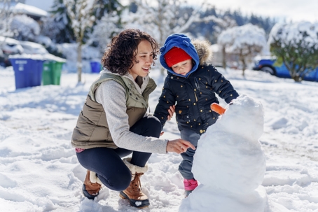mother playing with child in the snow
