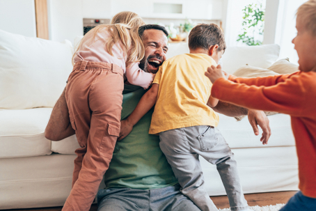 father playing with his children in the living room