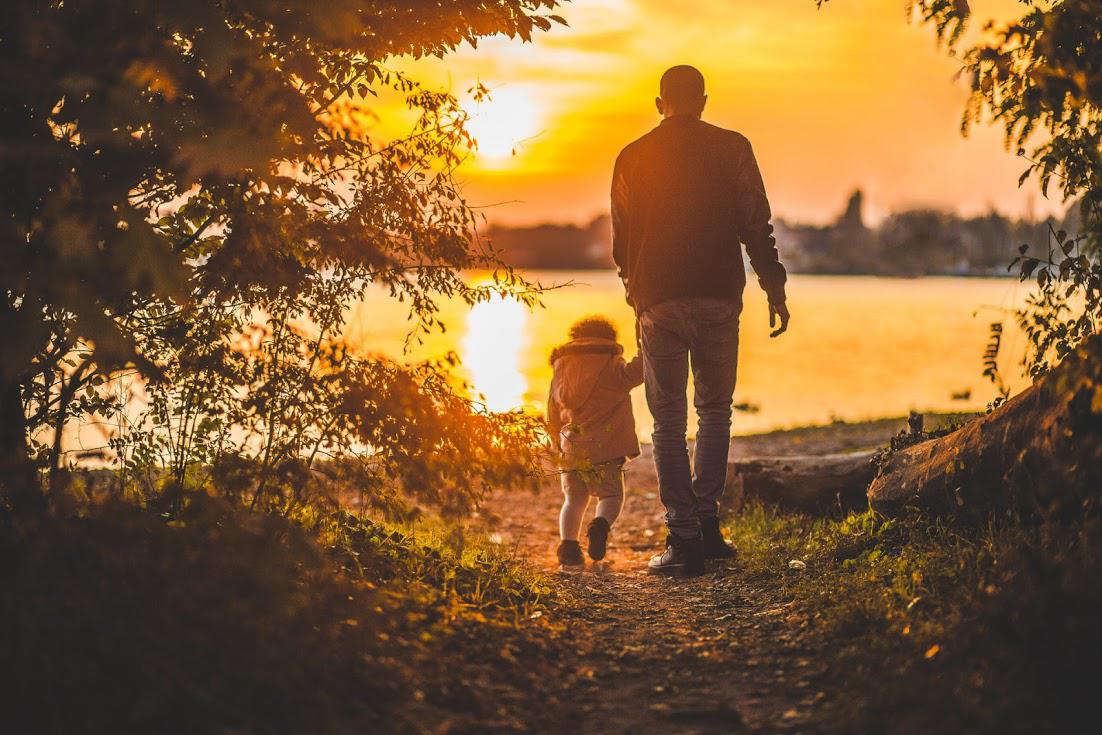 father and son in front of lake at sunset
